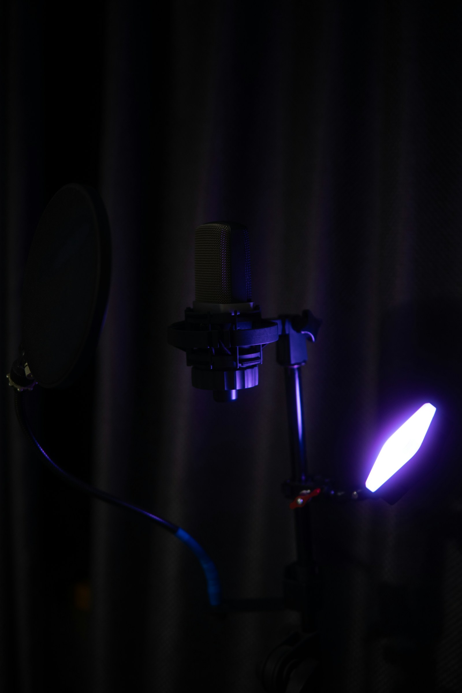 Condenser microphone illuminated by violet studio lighting