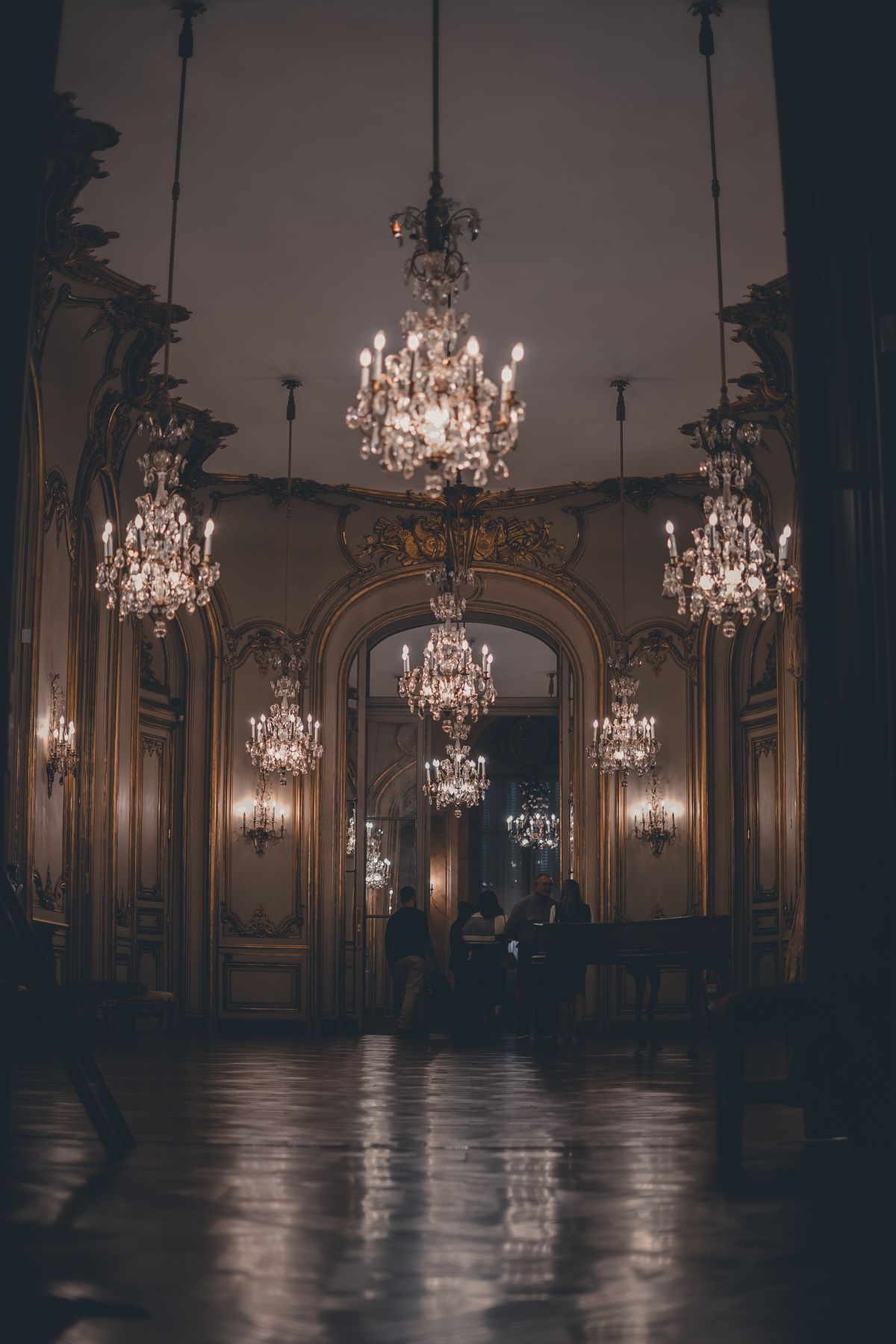 Ornate palace hall with glowing chandeliers and polished floors