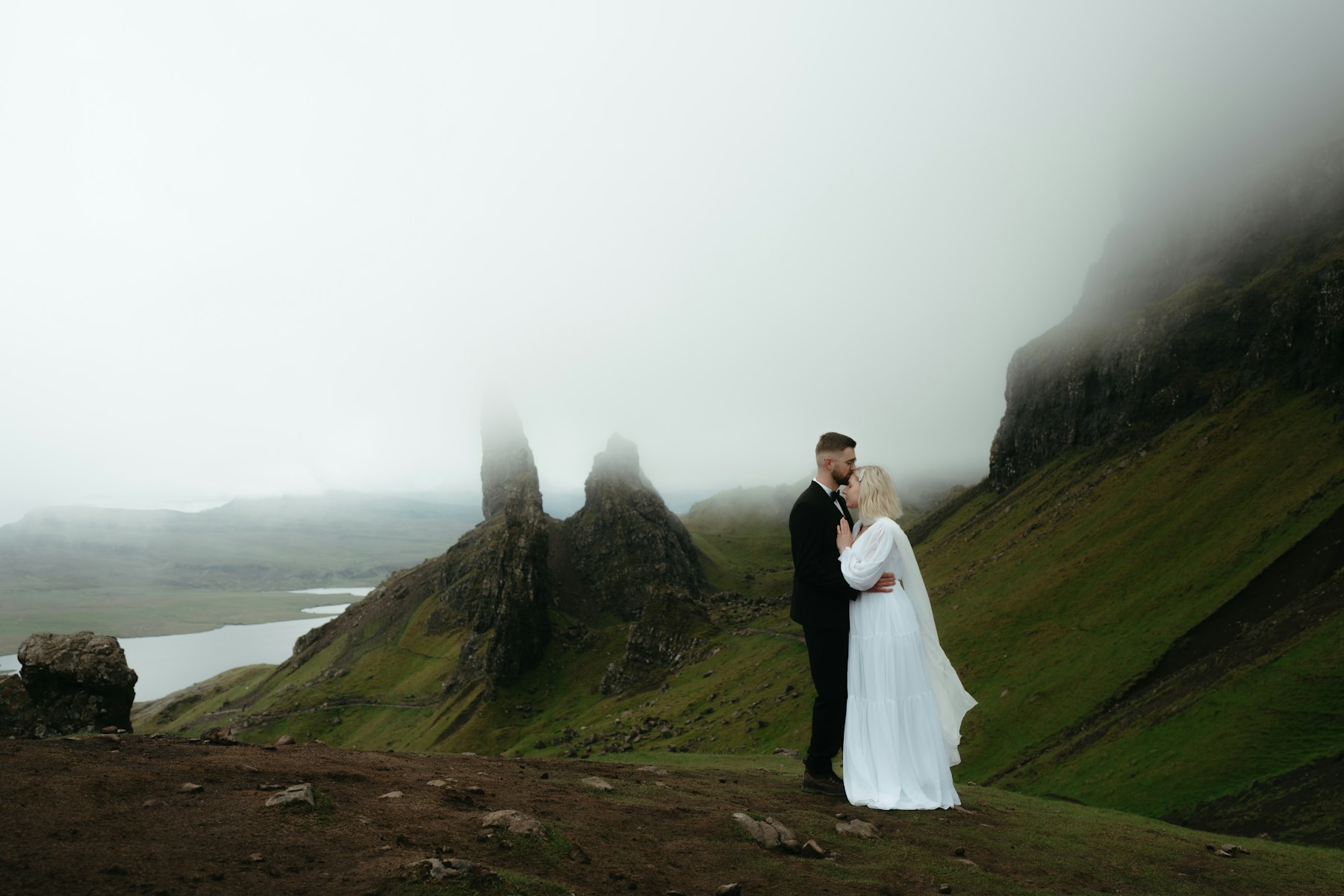 A newly married couple together on a misty mountain