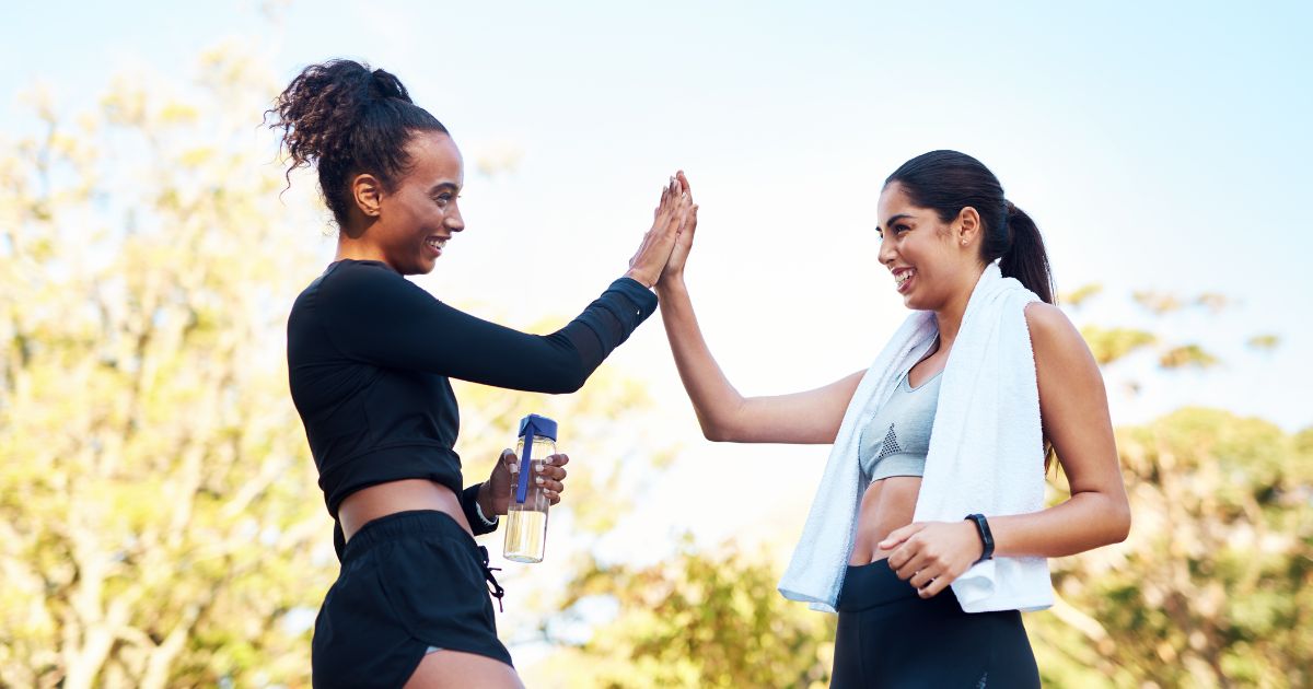Person wearing earphones checks pulse with fingers on neck while looking at a fitness tracker on the wrist.