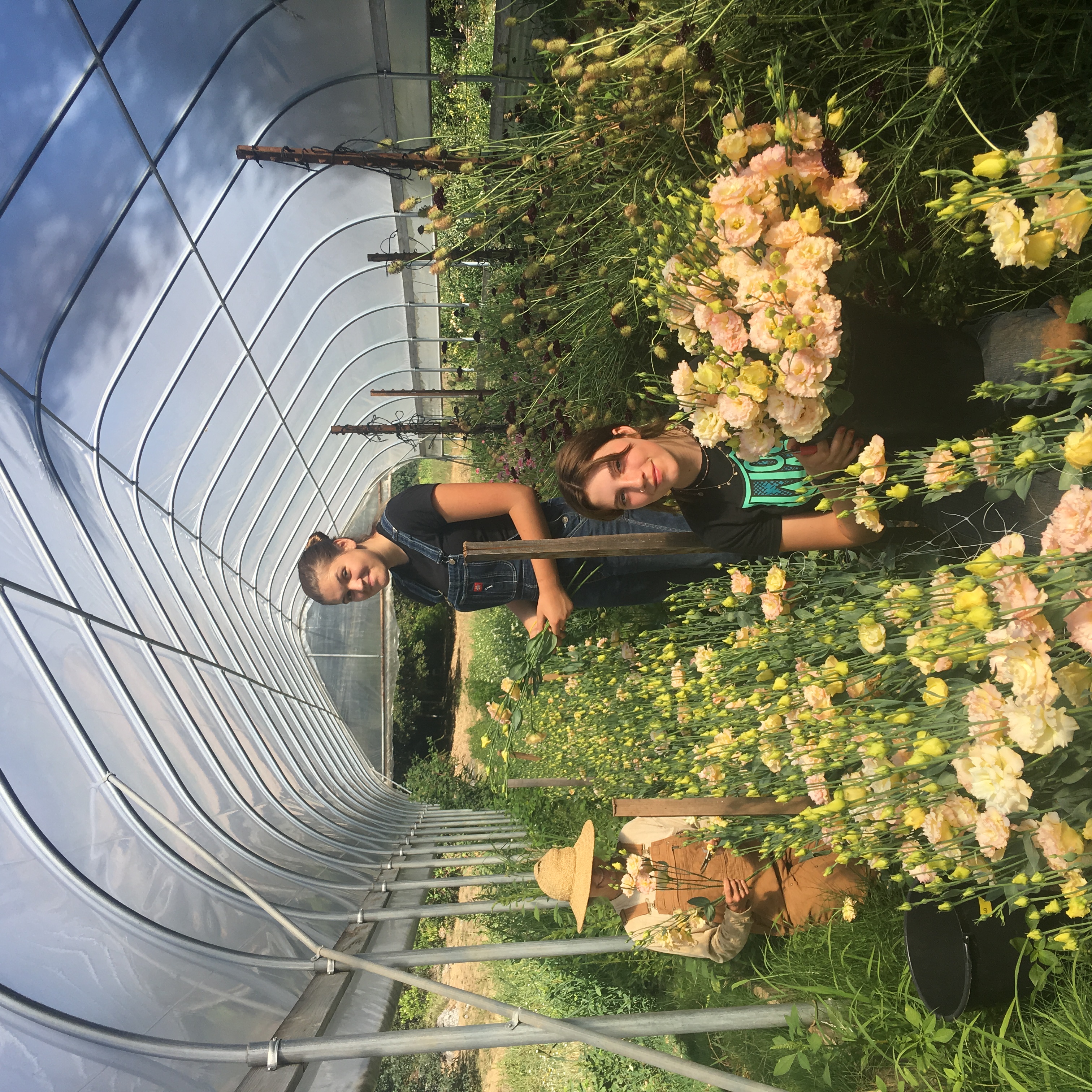 Three people holding bouquet of flowers