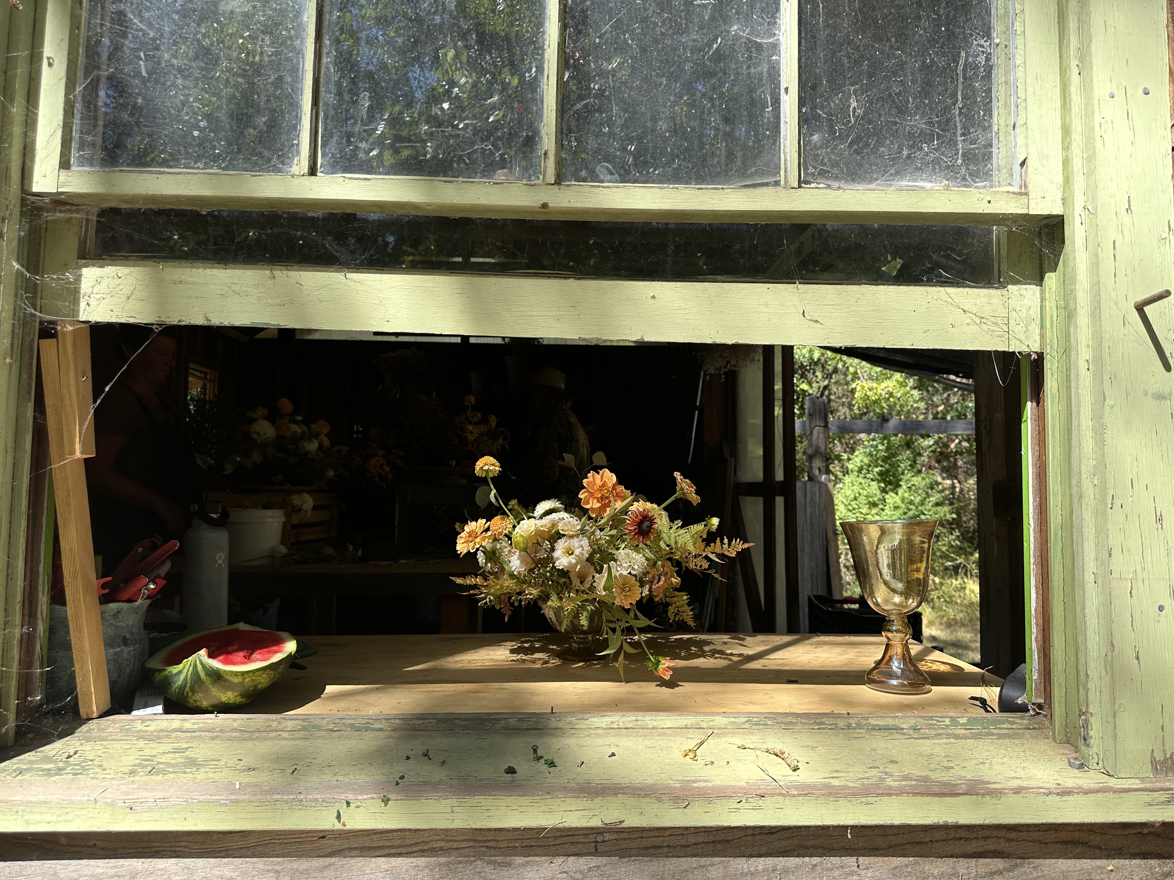 A bouquet of flowers sitting at a window sill