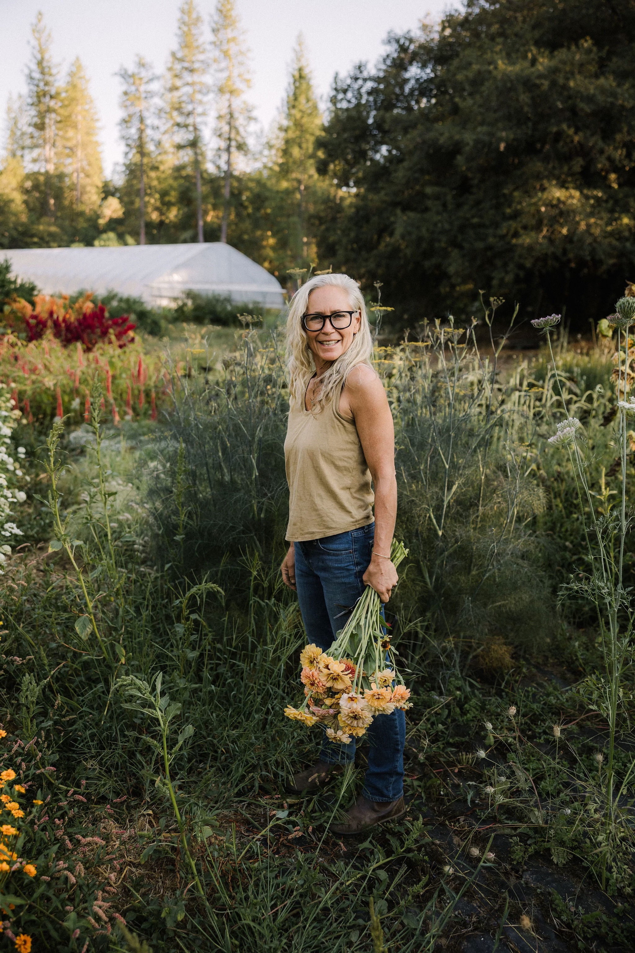 Angie in a field of flowers with bouquet in her hand.