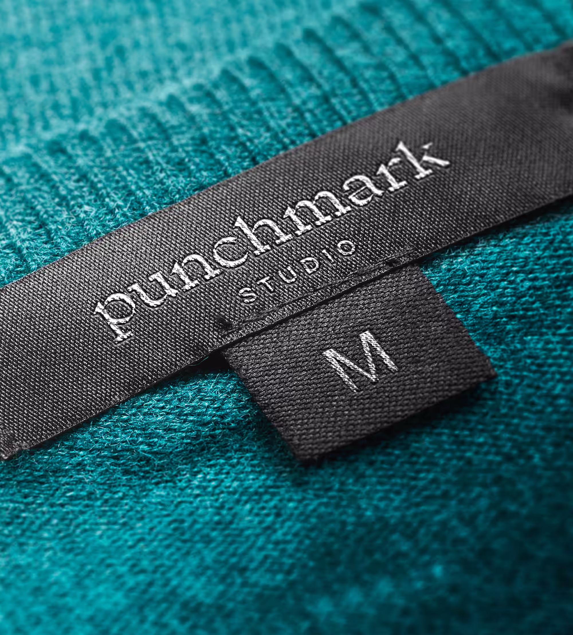 Close-up of Punchmark Studio custom woven apparel label