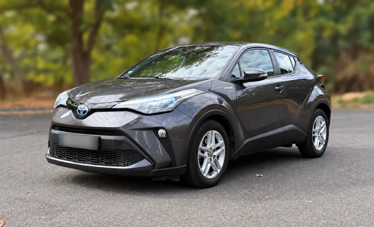Toyota C-HR hybride gris en forêt, vue trois quarts avant