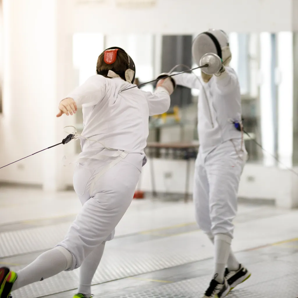Youth épée fencer executes a lunge during a training bout at Allez Fencing Club in Watertown, MA, highlighting form, footwork, technique and competitive mindset.