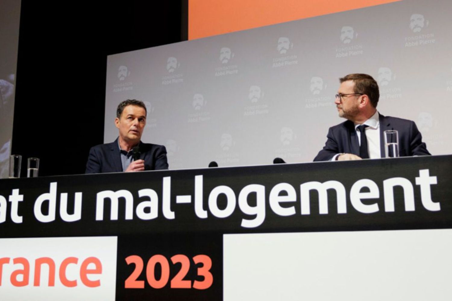 Deux hommes participent à une conférence sur le mal-logement en France, en 2023.