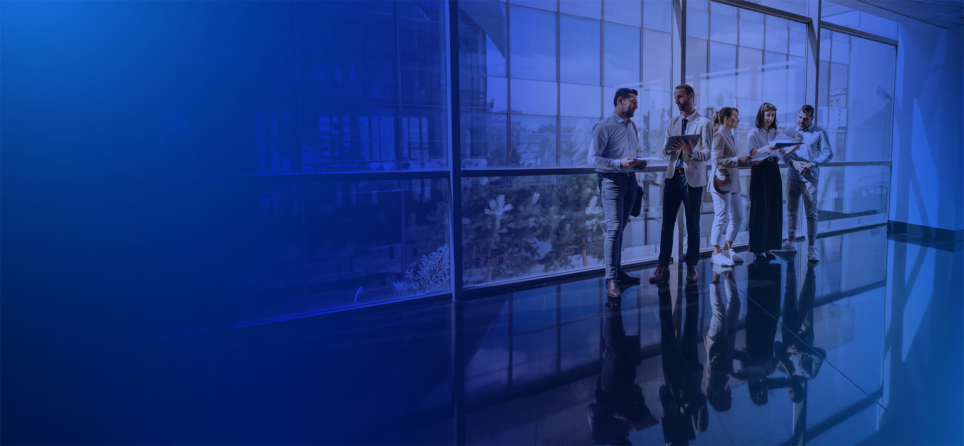 Team collaborating in a night glass office