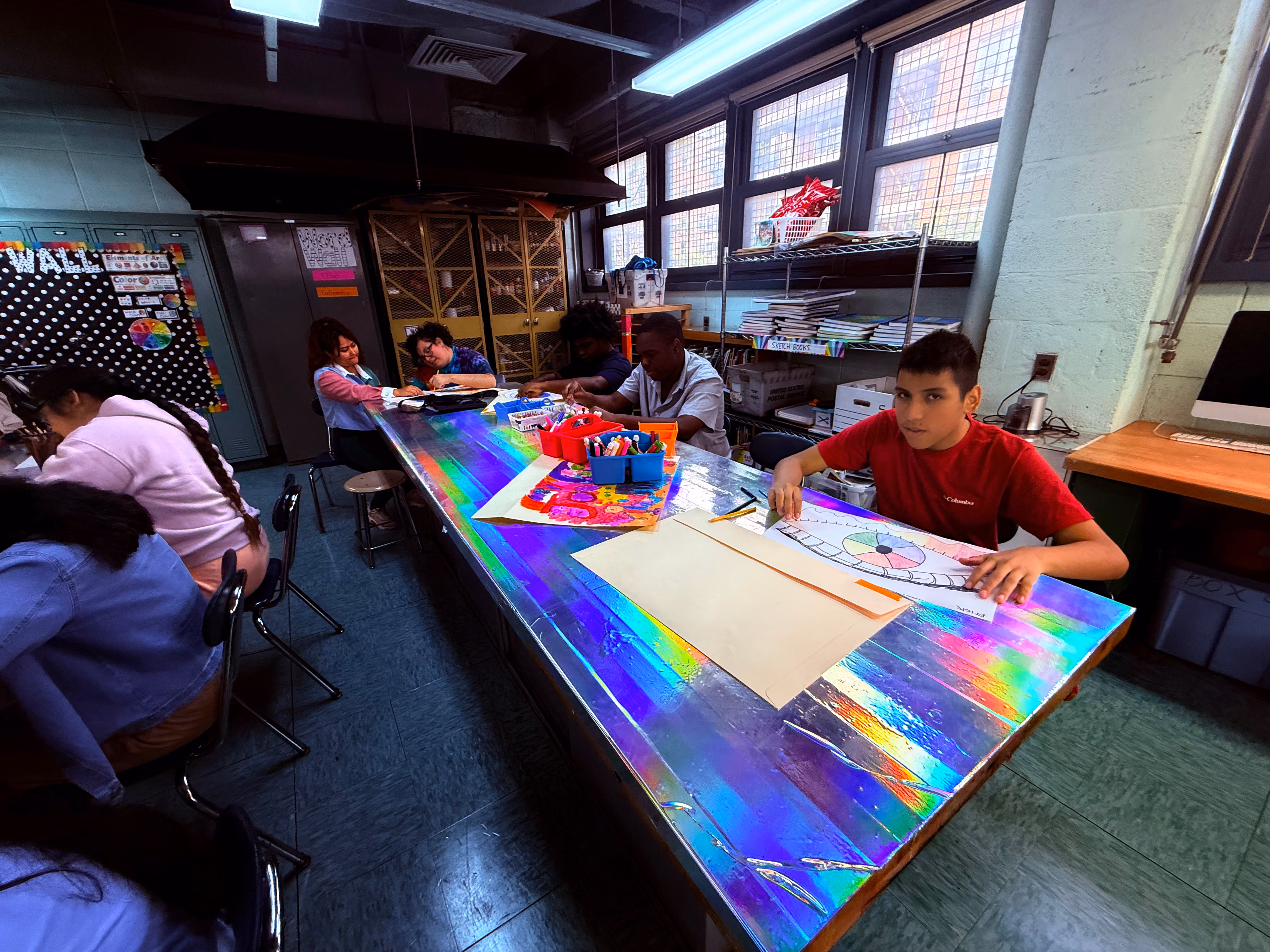 Students working on art projects at a colorful classroom table