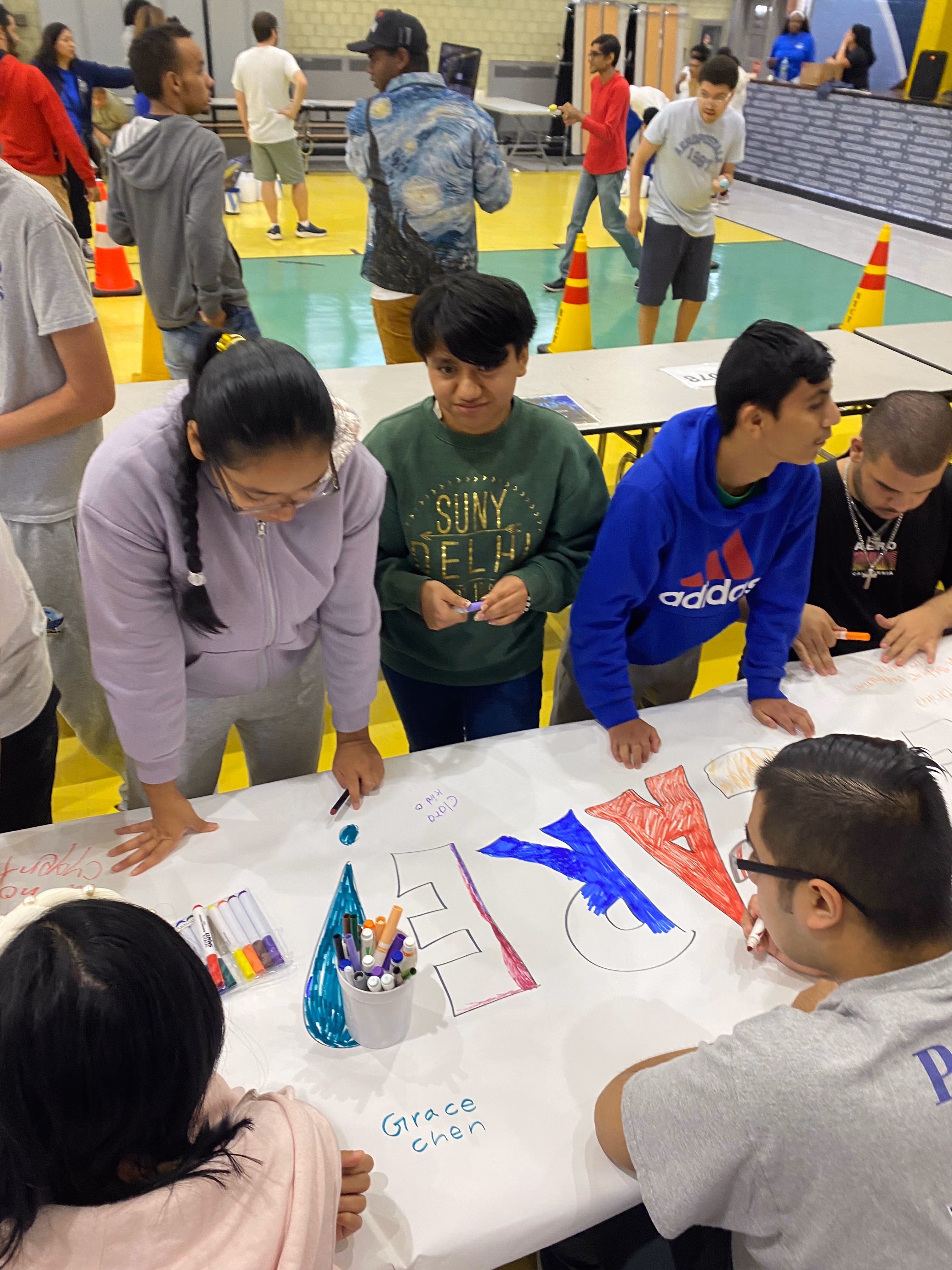 Students coloring a large banner together at a school event