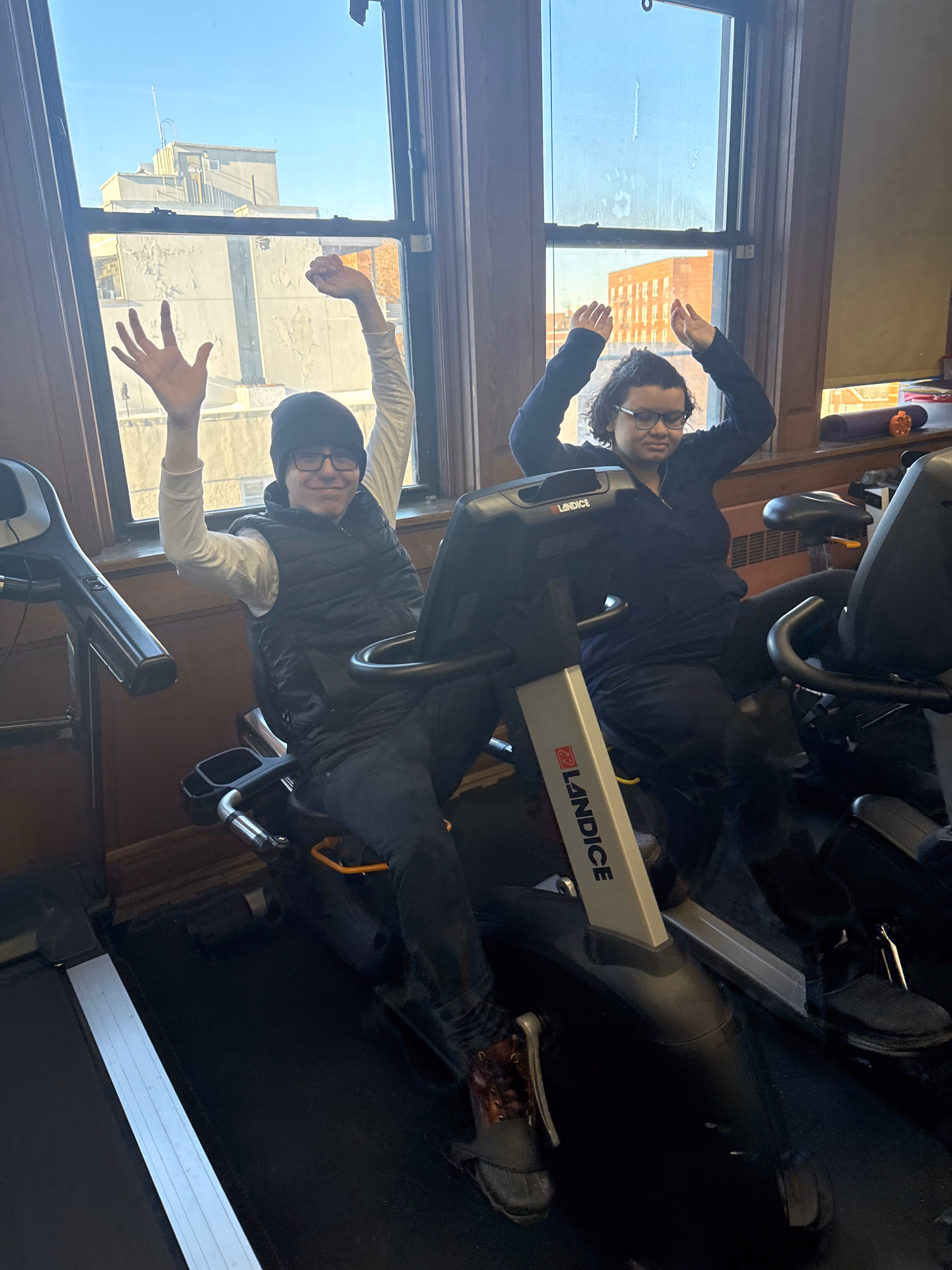 Two students using Landice exercise bikes in a school fitness room