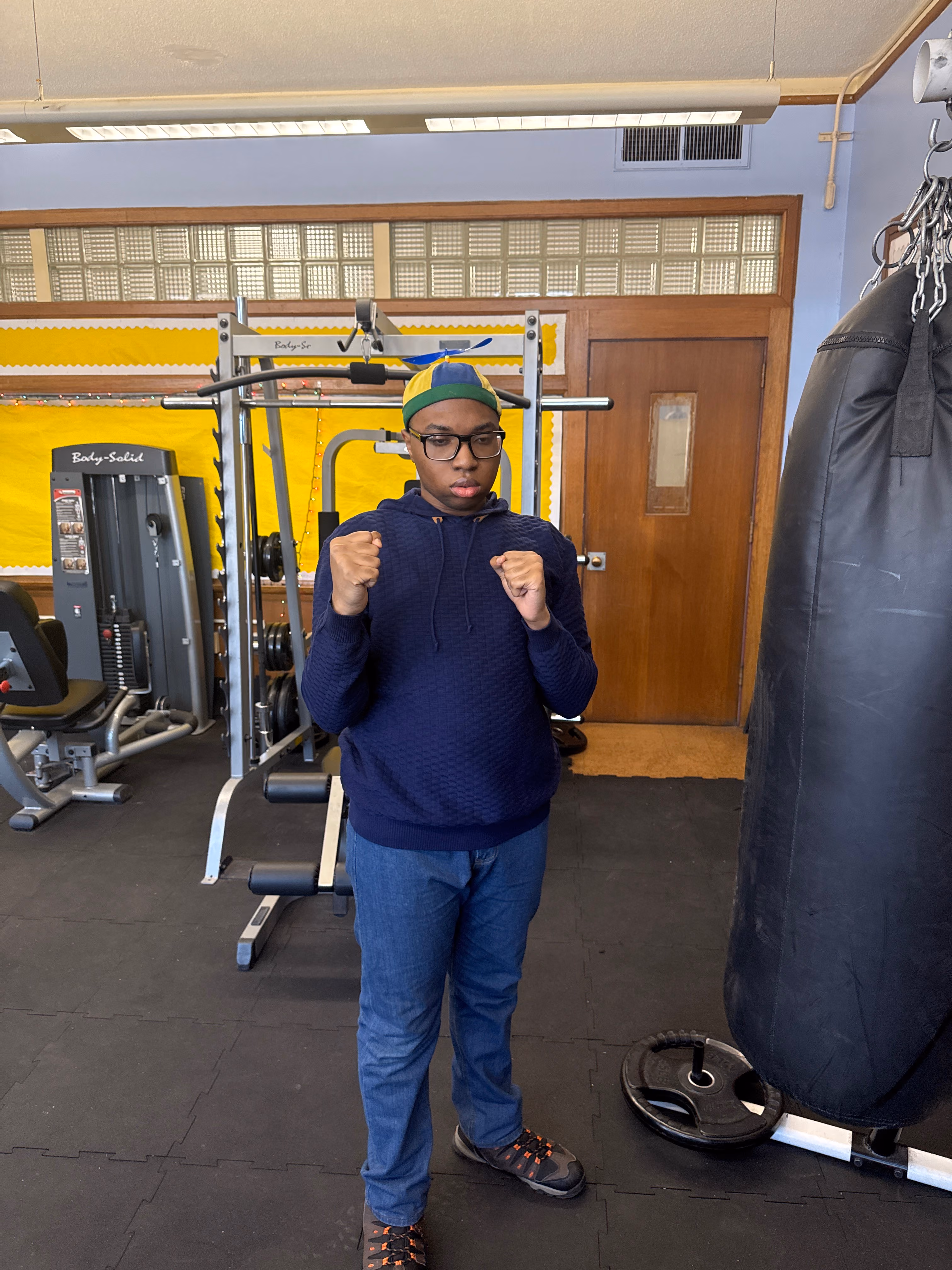 Student posing with fists raised in school fitness room