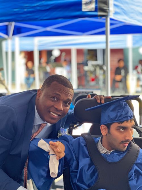 Principal congratulating graduate student in cap and gown at ceremony