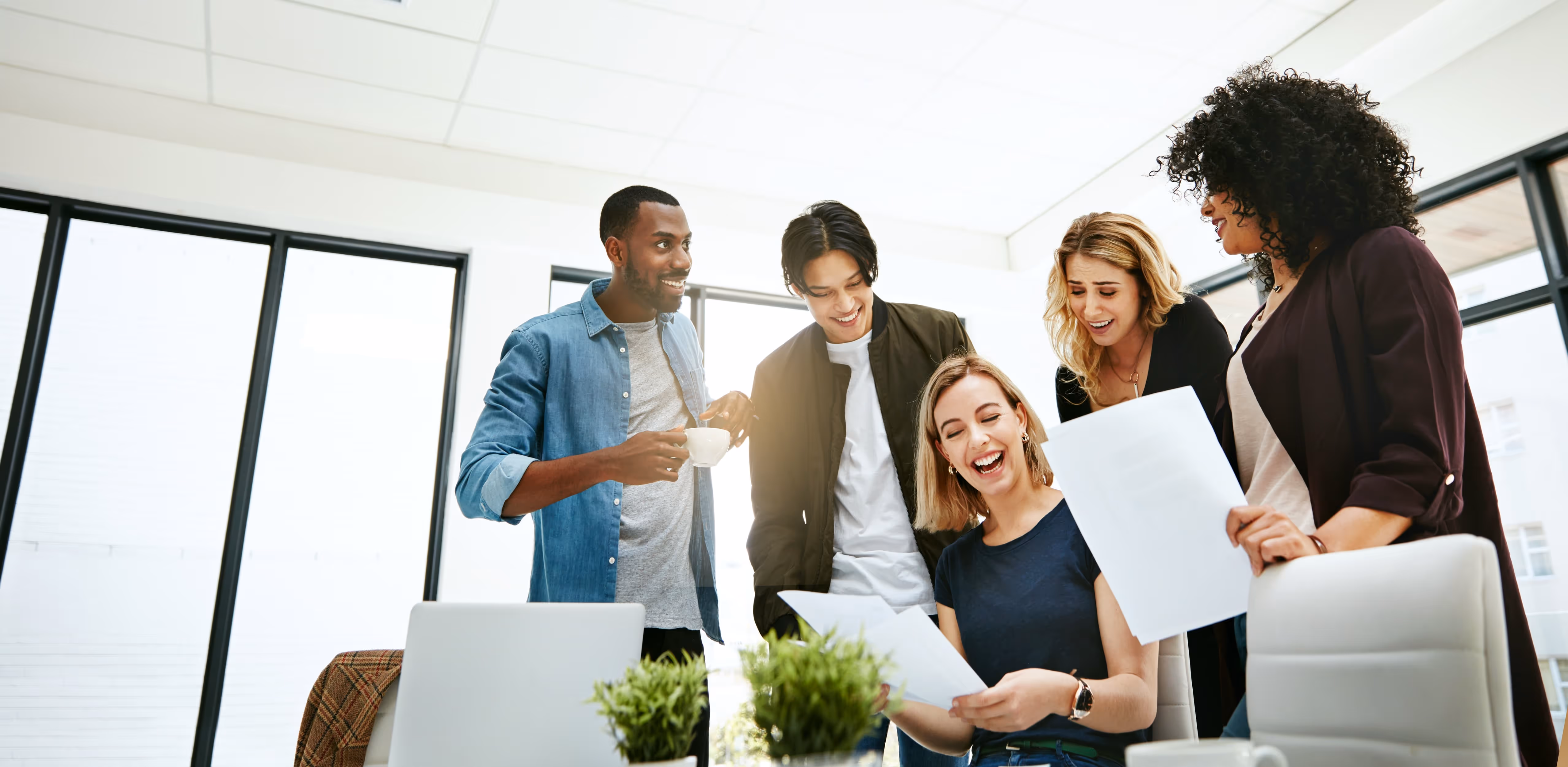 group of young professionals looking at paper smiling
