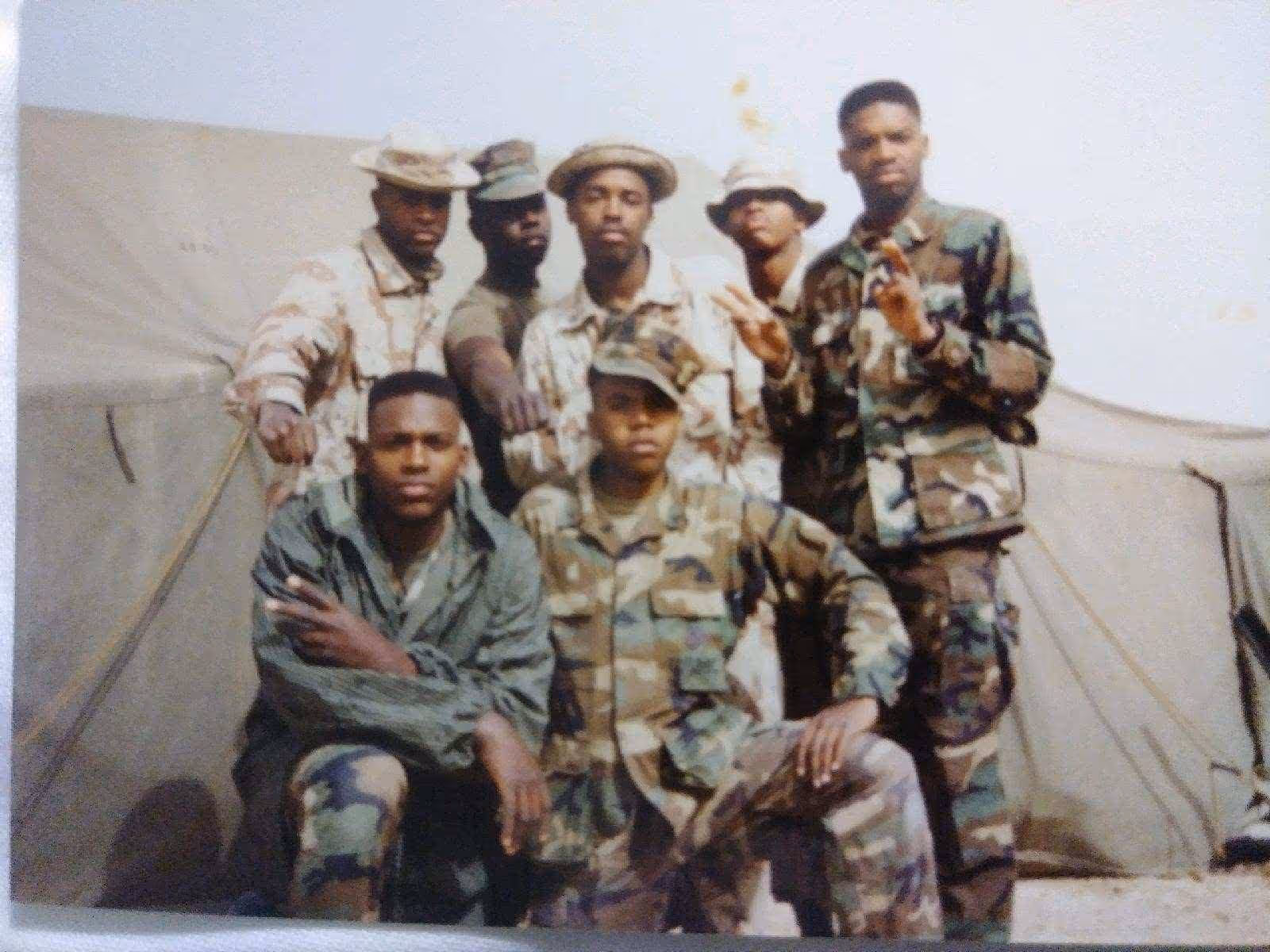 Group of U.S. Army soldiers posing in front of a military tent while wearing camouflage uniforms