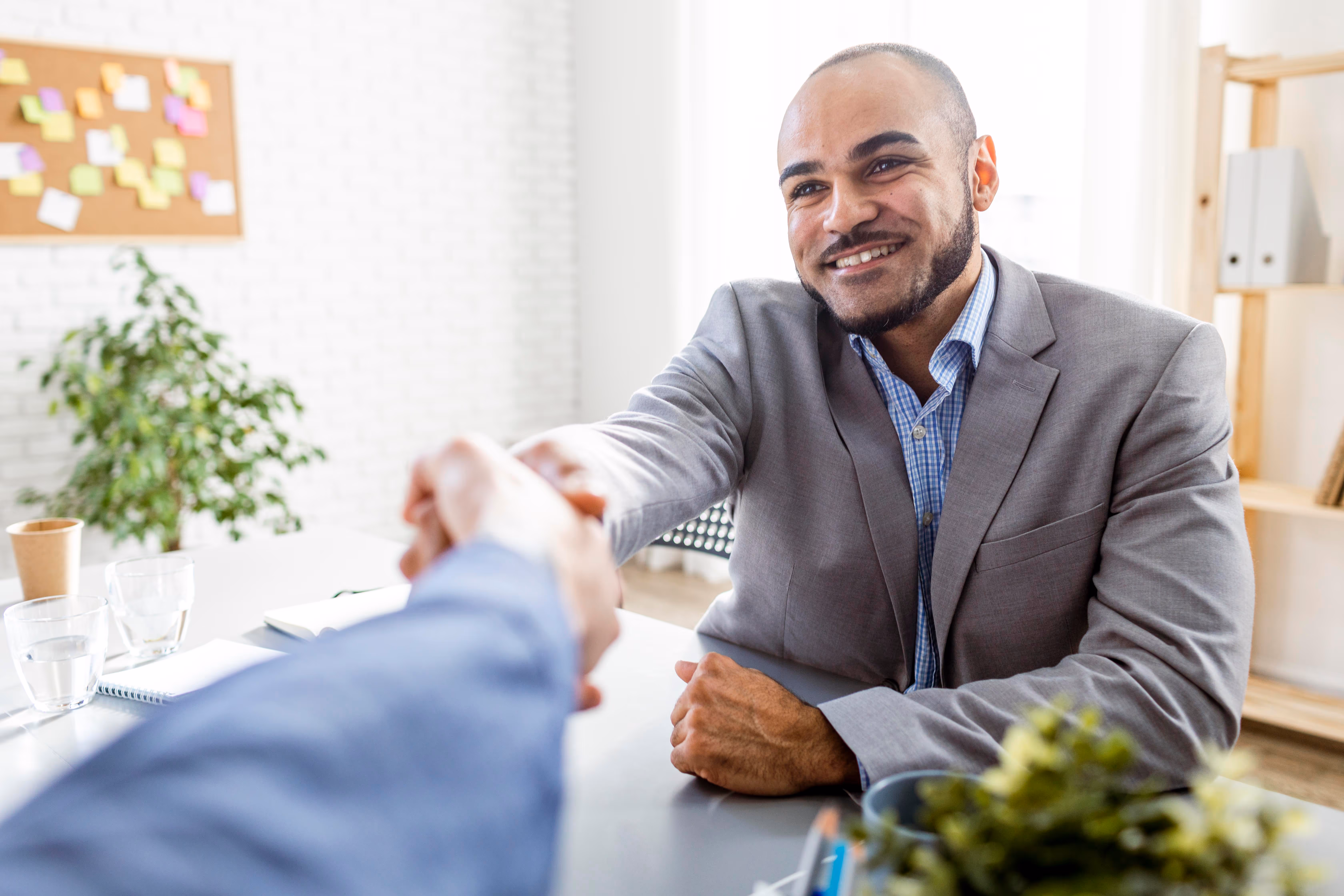 Corporate business men shaking hand of another person in about an office