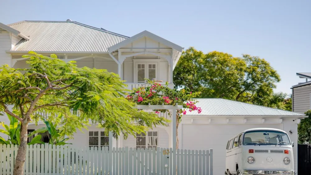 White weatherboard home with a picket fence