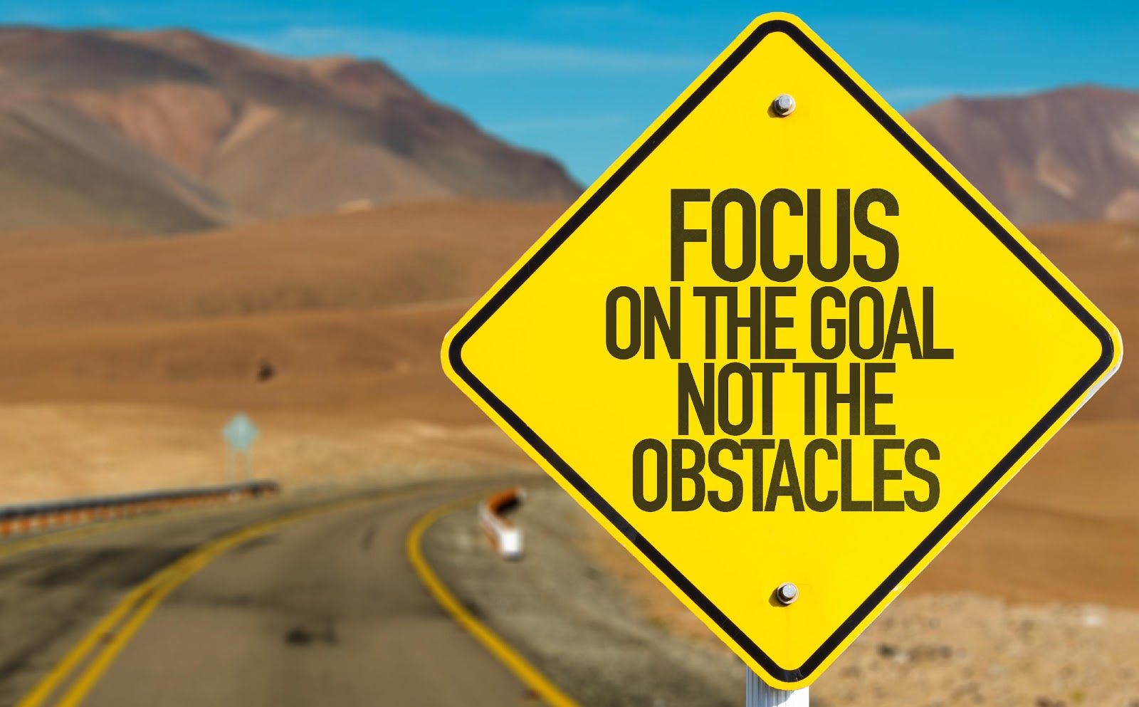 Motivational road sign about focusing on goals, not obstacles
