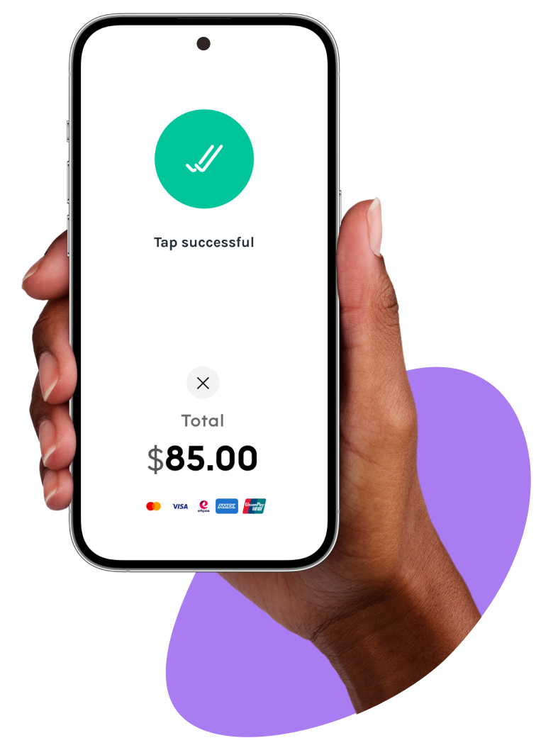 Hand holding a smartphone displaying a successful tap payment for $85.00 with multiple payment options, including Visa, Mastercard, and Amex.