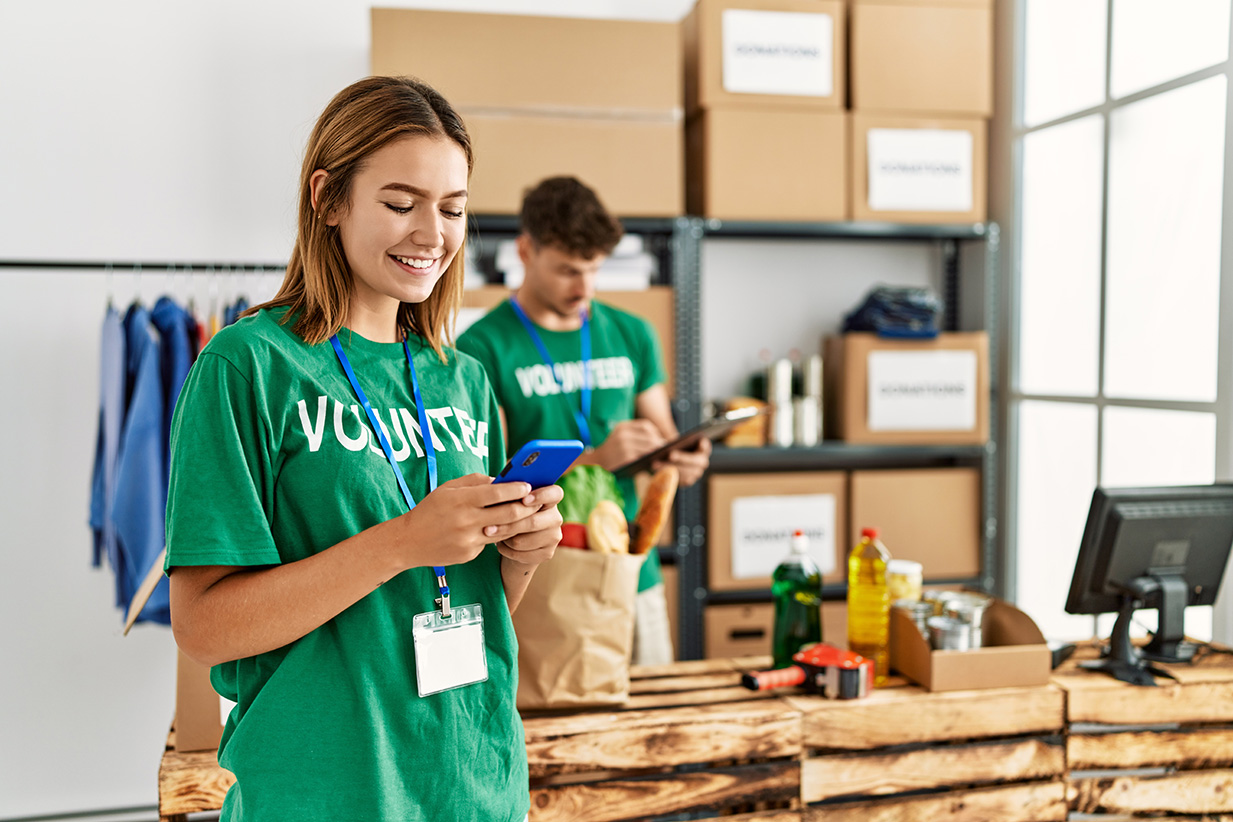 Charity volunteers using smartphones to manage donations at a fundraising event