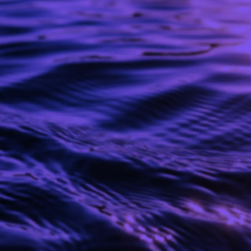 Close-up of blue and purple water ripples reflecting light.
