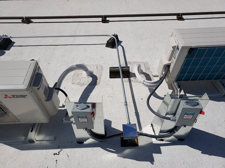 Mitsubishi HVAC units and their connections on a rooftop installation.
