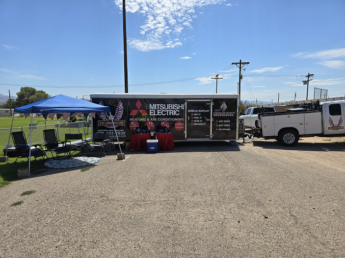 Mitsubishi Electric heating and air conditioning booth with seating at a community event.
