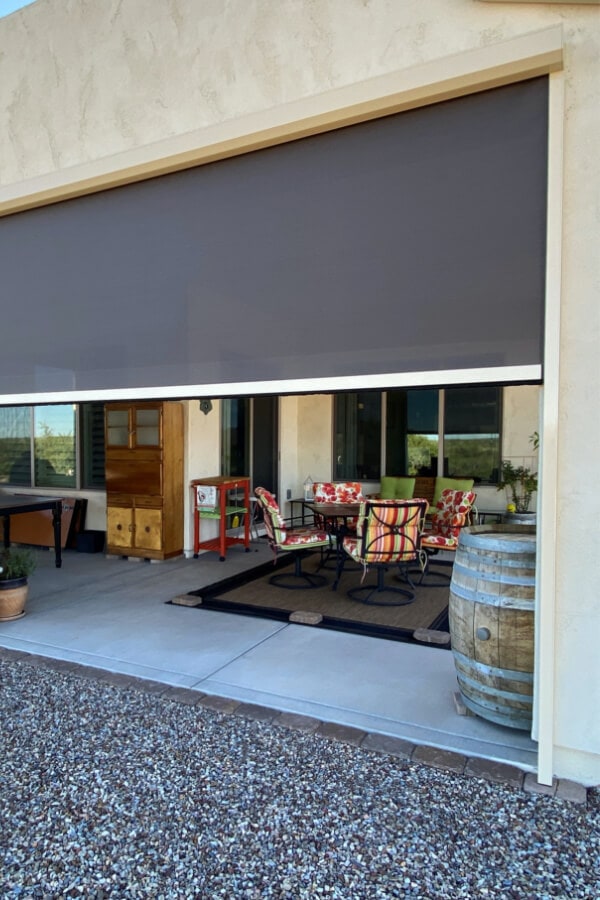 Image of an outdoor patio with a screen half-rolled down.