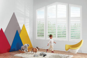 A child plays in his room with a dog on a leash behind him