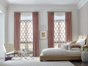 A large bedroom with a king-sized bed on a beige platform and a chair in the corner