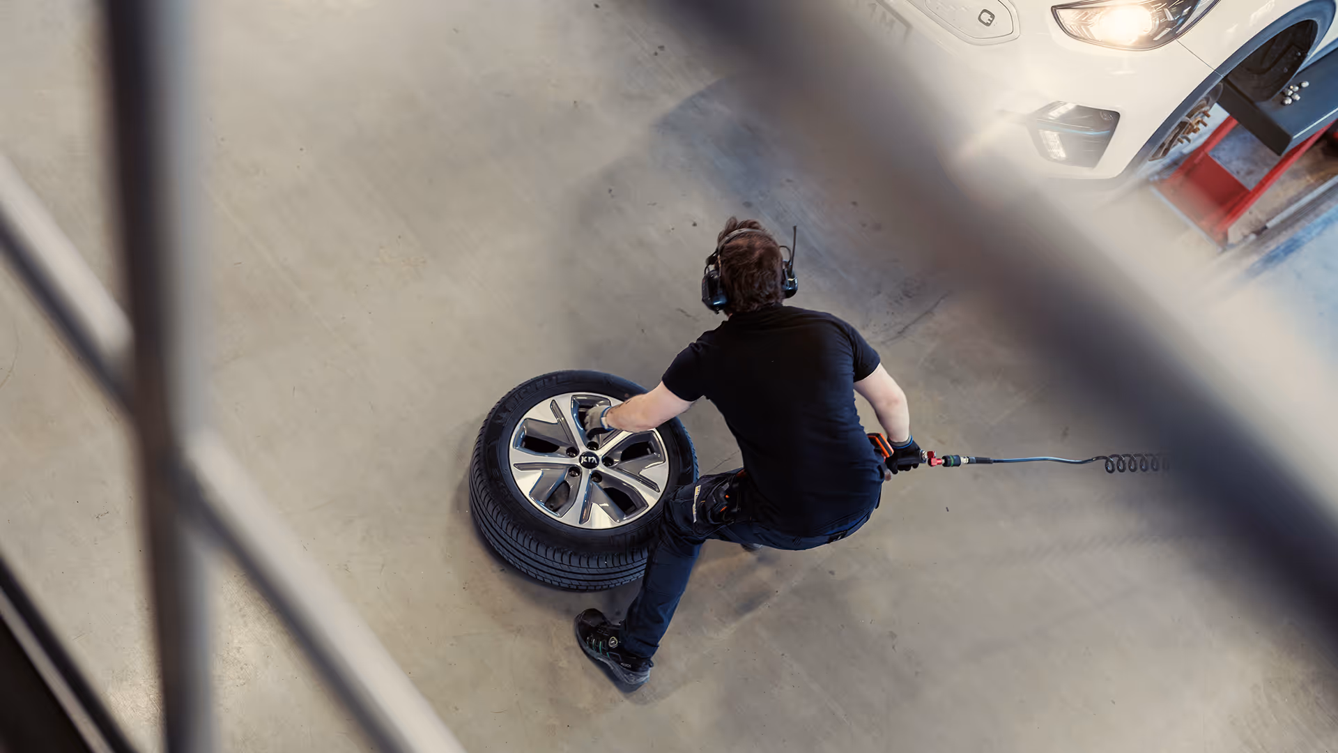A man seen from above working on a tire in a service center.