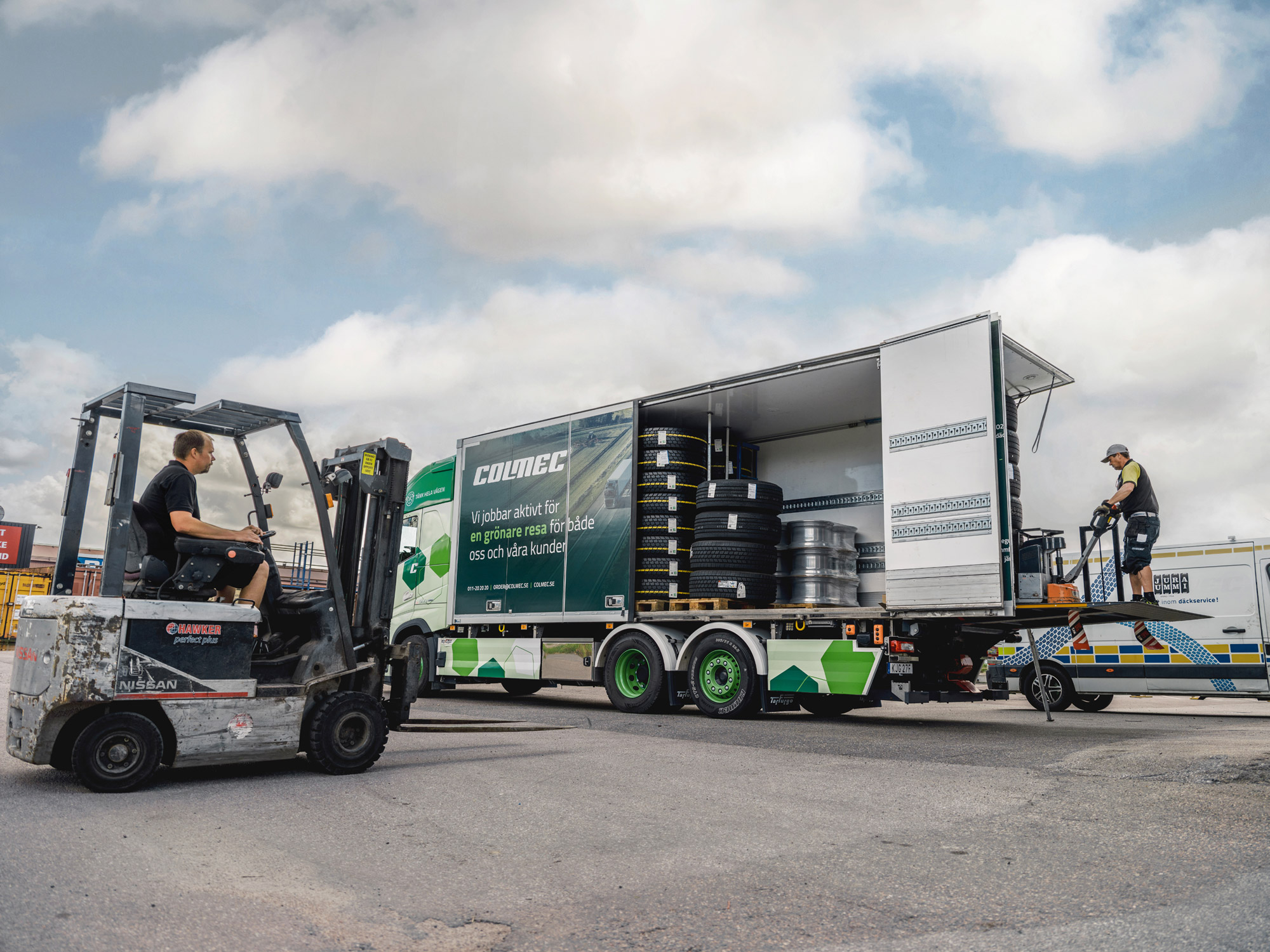large truck assisted by small truck with refurbished wheels
