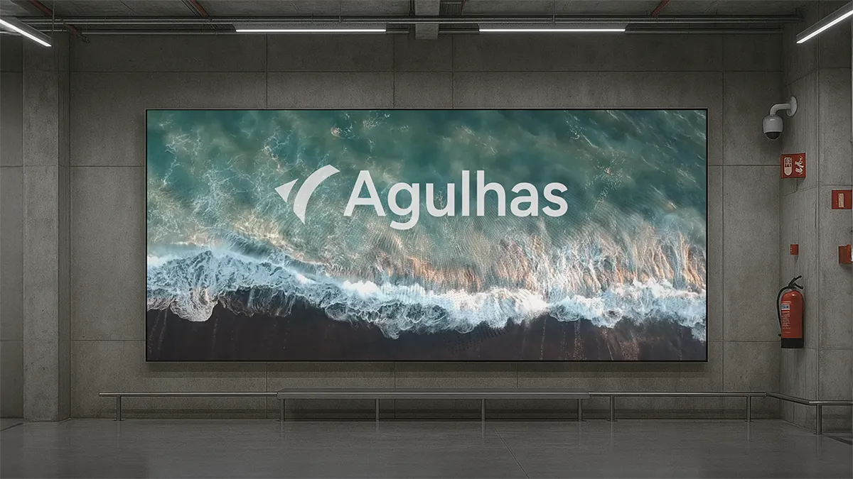 Large digital screen in concrete indoor space showing ocean waves with the word 'Agulhas'.