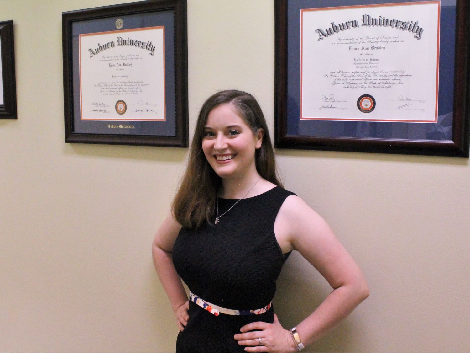 Dr Laura and Dr Teresa wearing black Citrus Hearing Clinic uniforms and glasses standing outdoors.