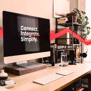 Moderner Arbeitsplatz mit Desktop-Computer, auf dem "Connect. Integrate. Simplify." angezeigt wird – Theobald Software Büroeinrichtung.