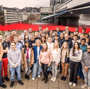 Group photo of Theobald Software employees with a red string of data in the background.