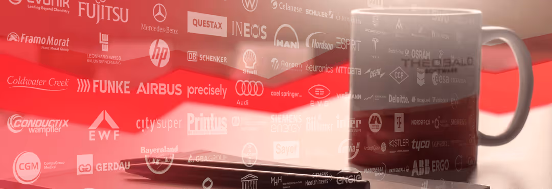 Coffee mug on a desk with logos from Theobald Software partners.