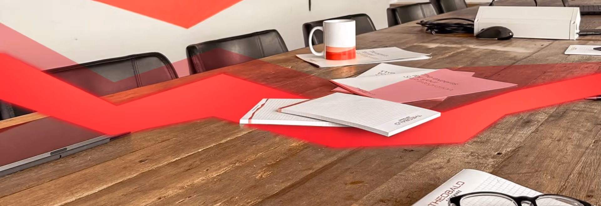 Meeting table with documents and coffee cups with a red string of data.