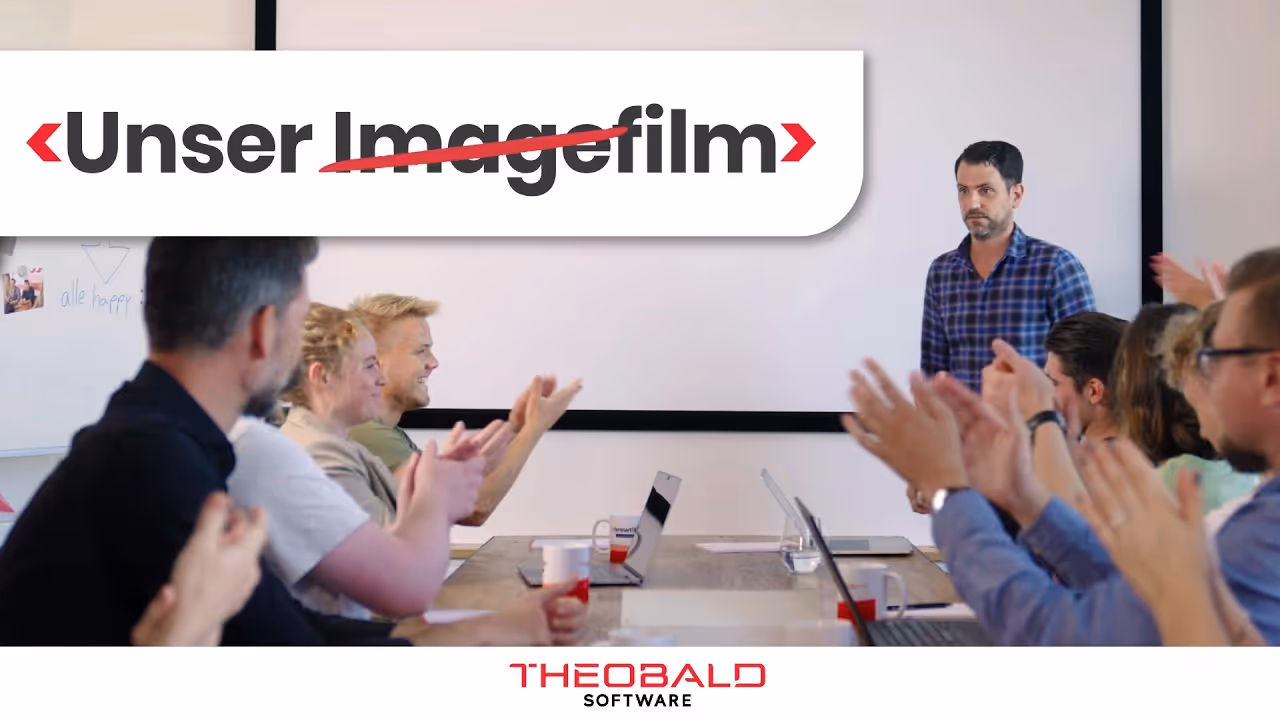 A man stands in front of a group of people and talks about Theobald Software, the picture shows our image film.