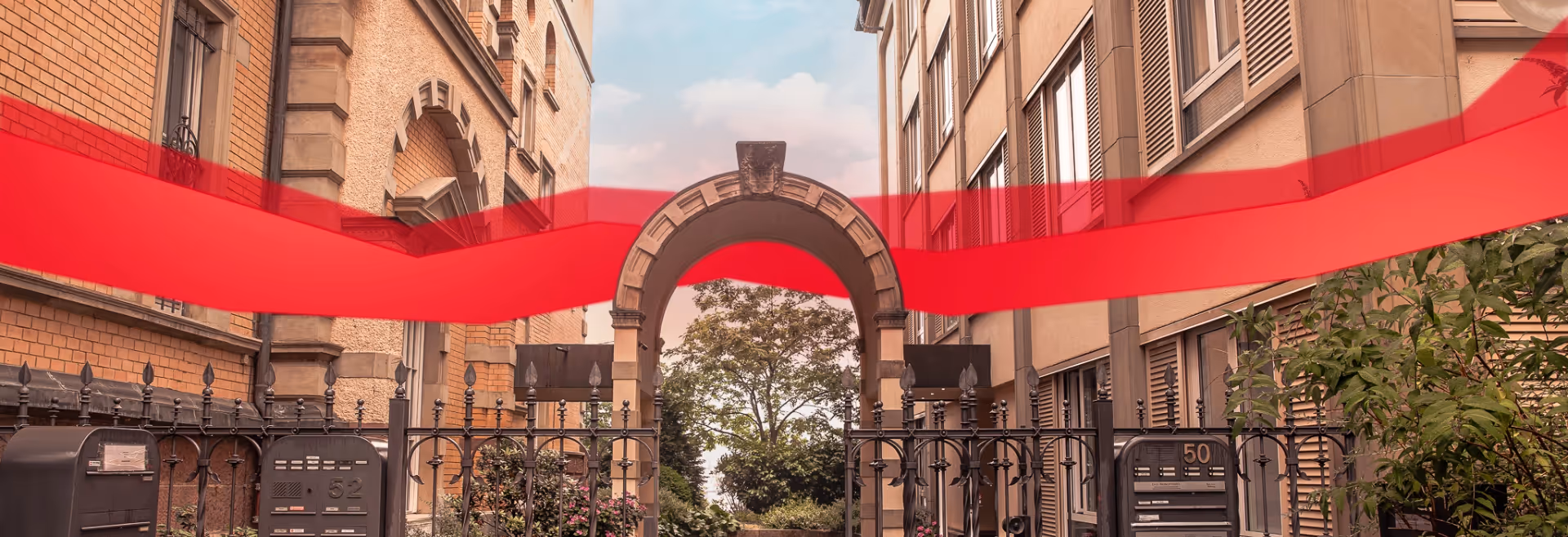 Archway between two old buildings with a red data line, input from Theobald Software in Stuttgart.