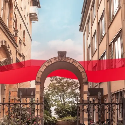Torbogen zwischen Altbauten mit rotem Band – Eingang von Theobald Software in Stuttgart.