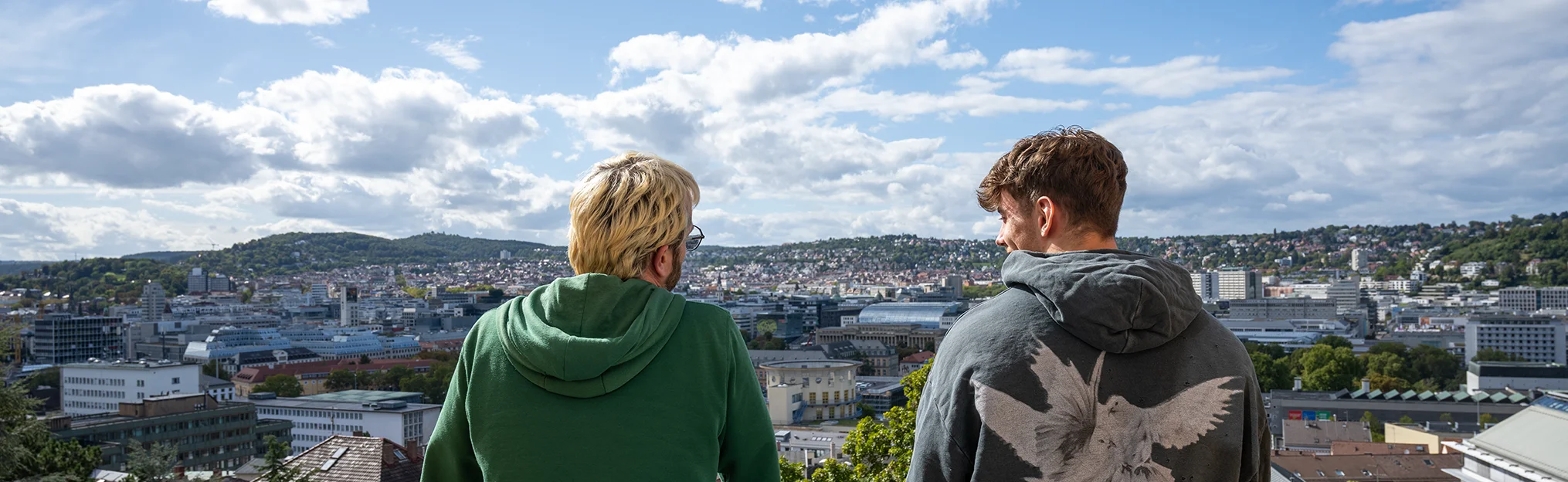 Zwei Männer stehen auf einem Balkon und schauen über Stuttgart.