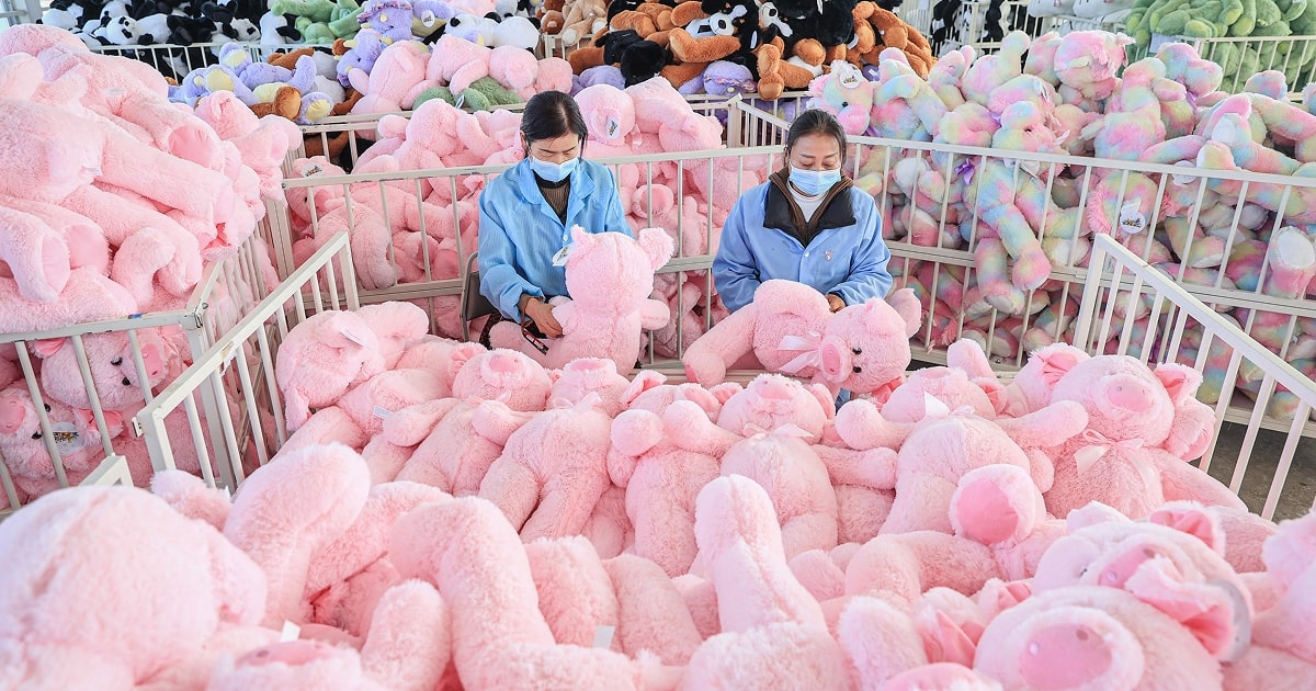 Two female workers assemble pink toys in a factory in China. 