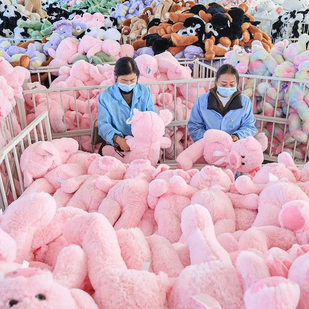 Zwei Arbeiterinnen montieren in einer Fabrik in China rosa Spielzeug.