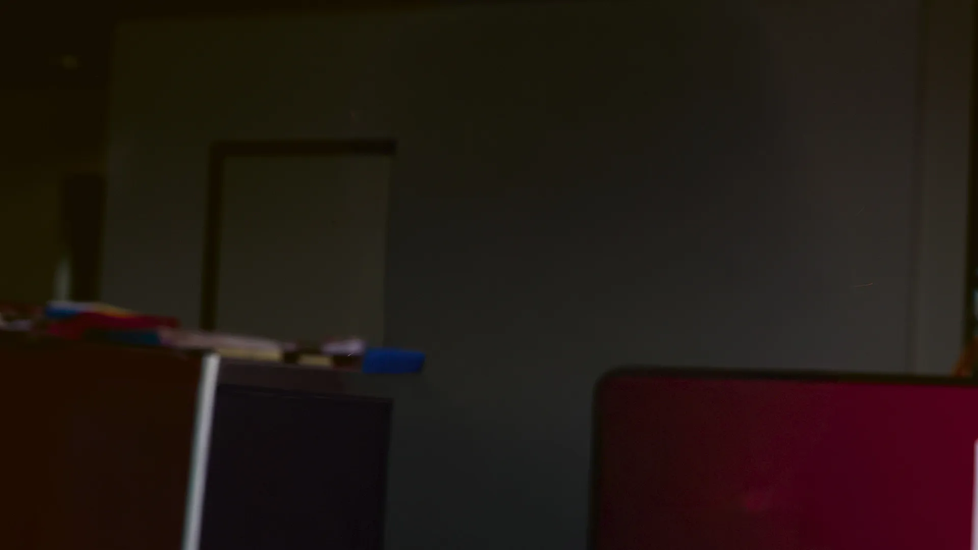 A dark background depicting an office setting. 