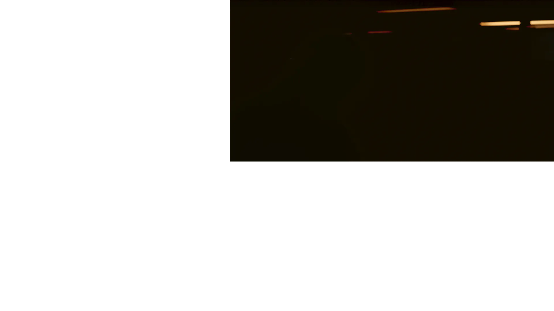 Black cropped image of a dark space with a lamp illuminating the top right corner. 