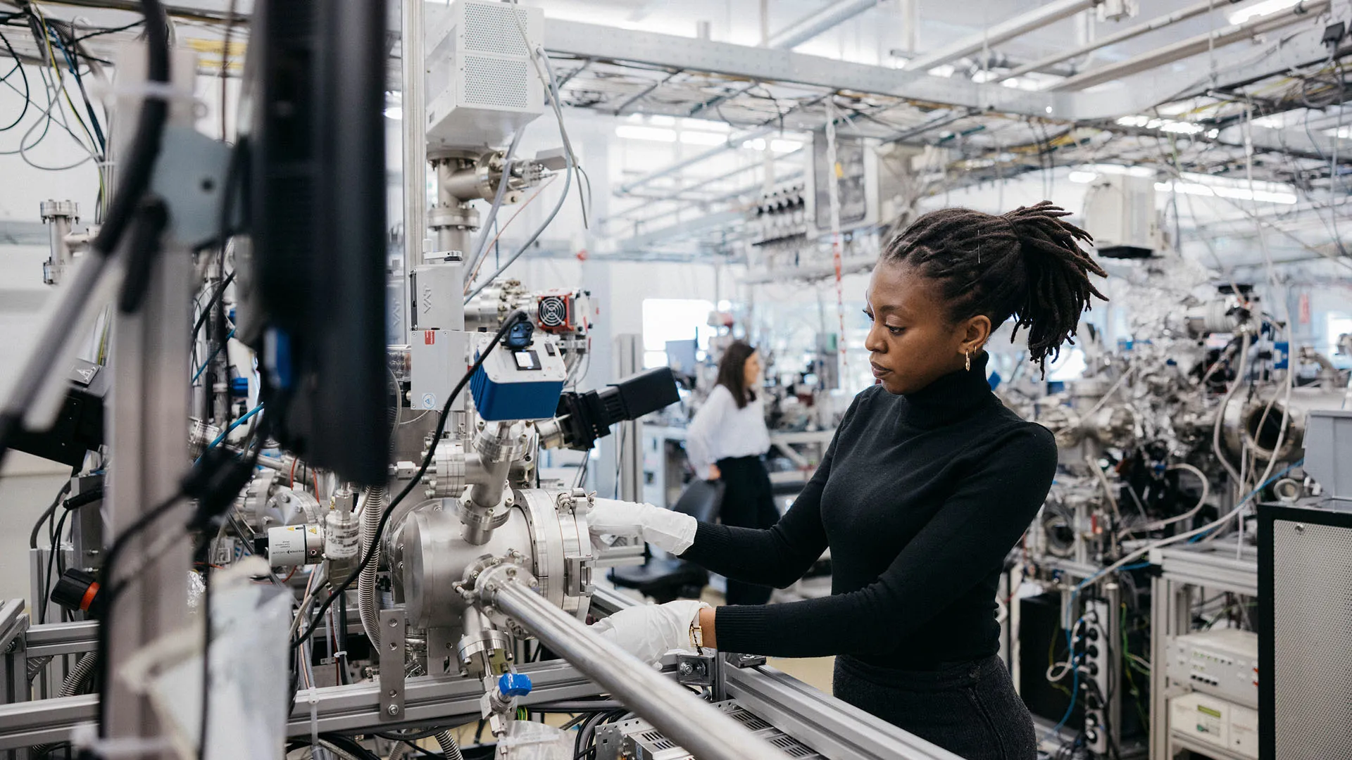A researcher works with advanced laboratory equipment at a high-tech facility. 