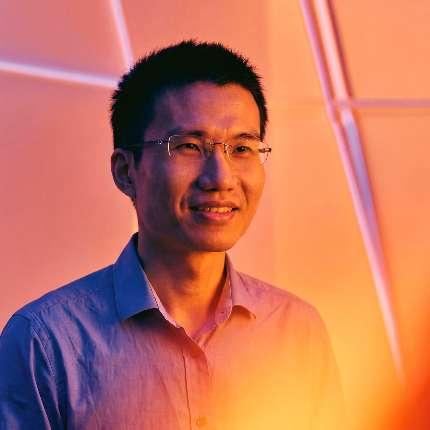 KI-generiertes Porträt von Kaifu Zhang, Gründer von drillr.ai, mit stilisierter pink-oranger Beleuchtung.