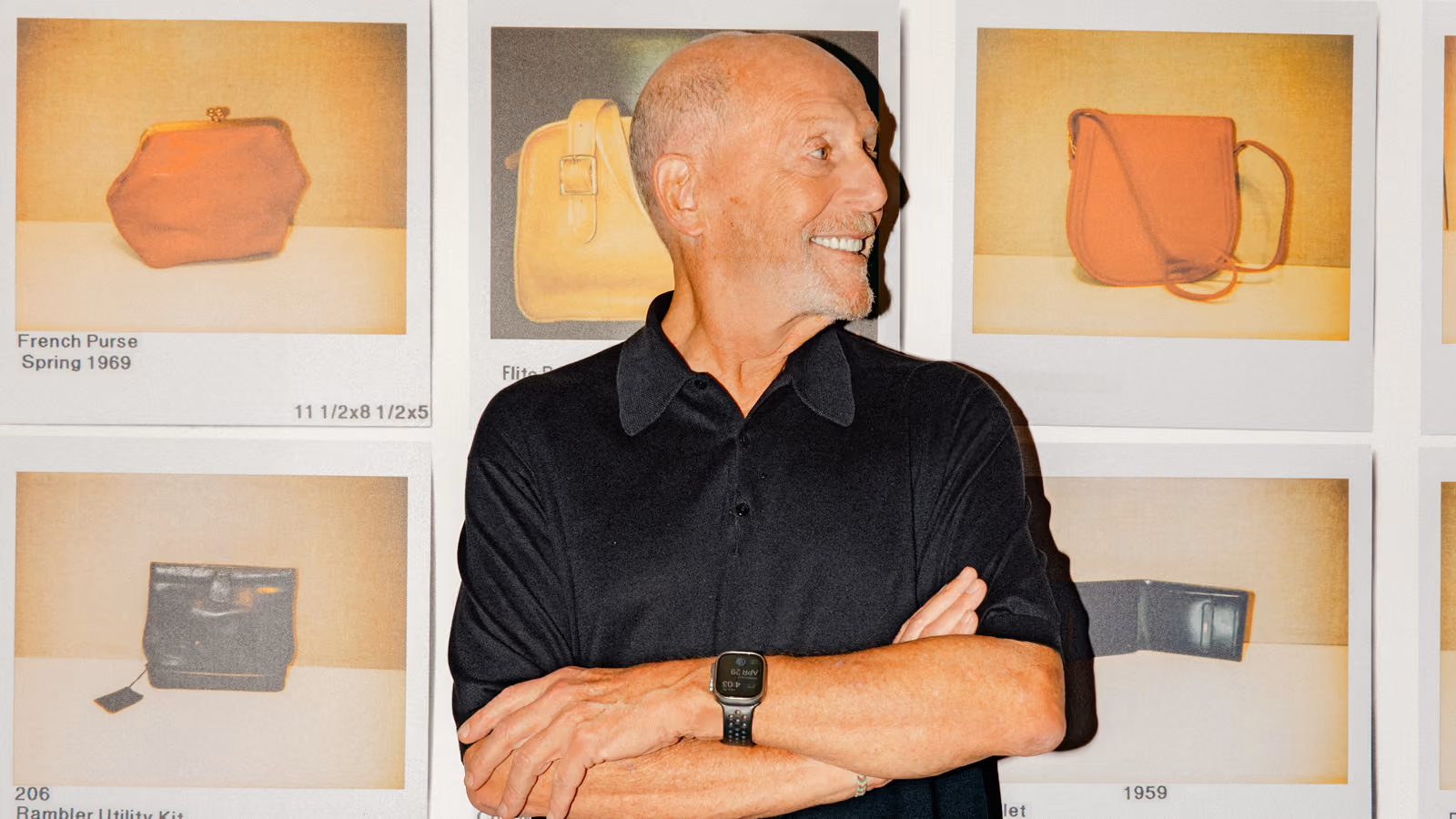 Lew Frankfort vor einer Archivwand mit Polaroidfotos, die Jahrzehnte an Coach-Taschendesigns dokumentieren.