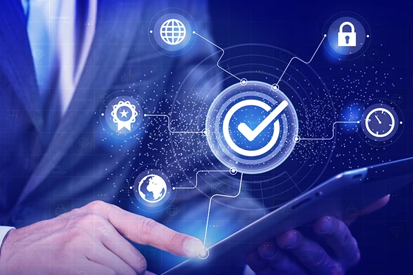 Business professional using tablet with cybersecurity and compliance icons overlay.